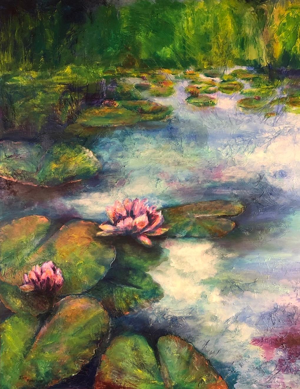 Pink water lilies open on a still pond, lily pads crowding the near bank and the sky reflected in the water.