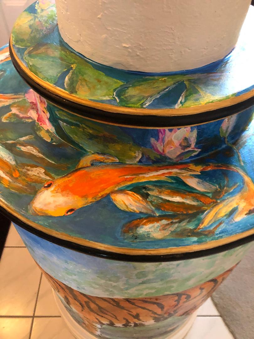 Koi and water lilies painted around the stepped rings at the base of an interior column.