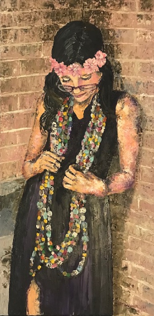 A woman in a dark dress and a crown of pink flowers, head bowed, gathering long strands of coloured beads against a brick wall.