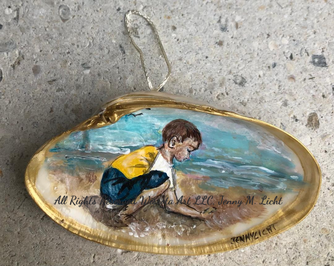 A gilt-edged shell ornament painted with a boy in a yellow shirt crouching to dig in the wet sand.