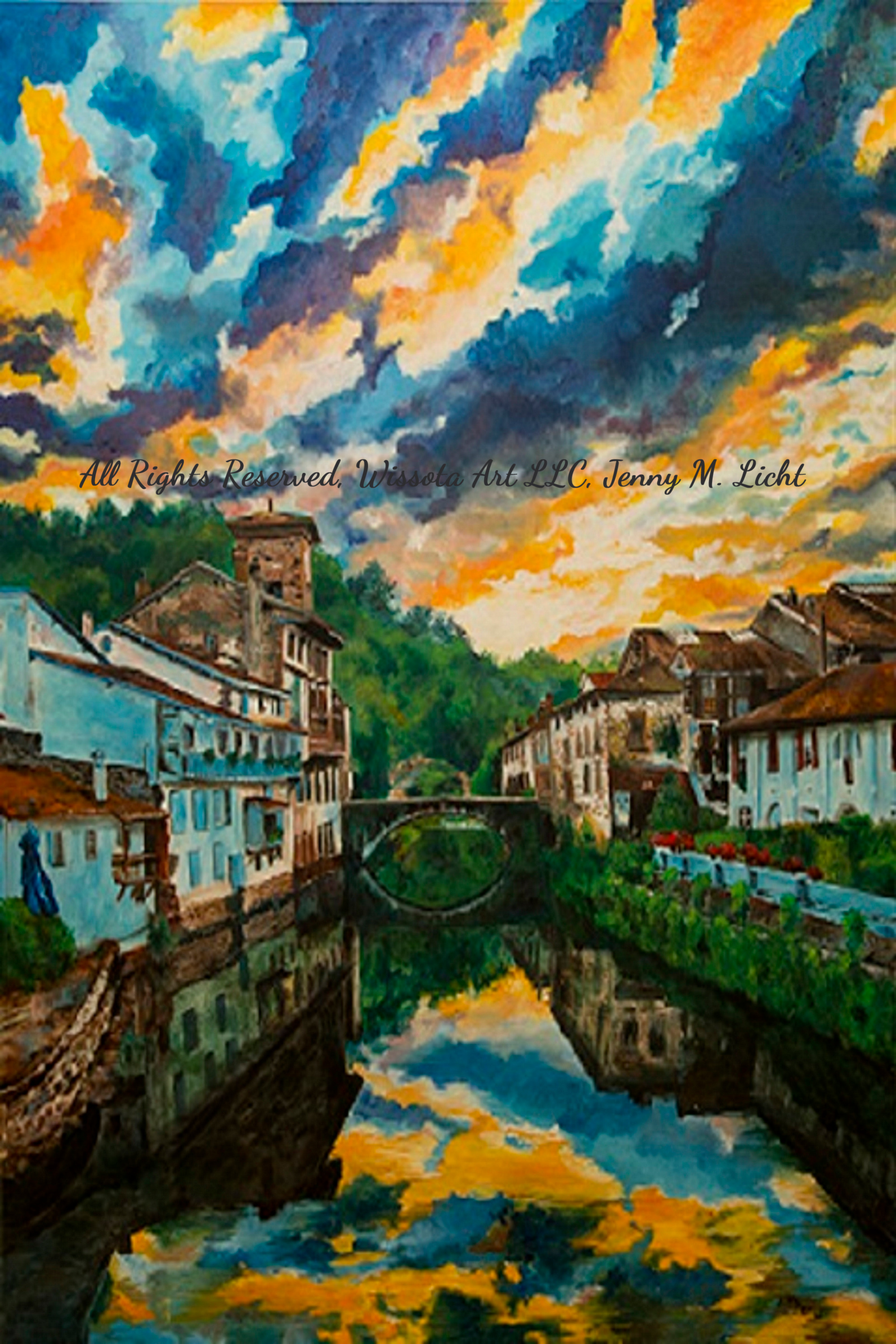 A European riverside village with a stone footbridge, the whole sky of orange and blue cloud mirrored in the still water below.